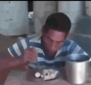 a man in a striped shirt is sitting at a table eating food from a bowl .