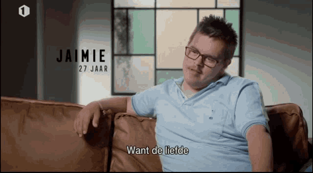 a man with down syndrome sits on a couch and says want de liefde in a foreign language