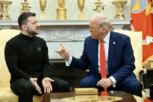 two men are sitting on a couch and one of them is wearing a shirt that says ' ukraine ' on it