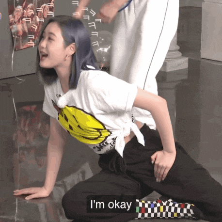 a girl with blue hair is kneeling down and says i 'm okay on the bottom