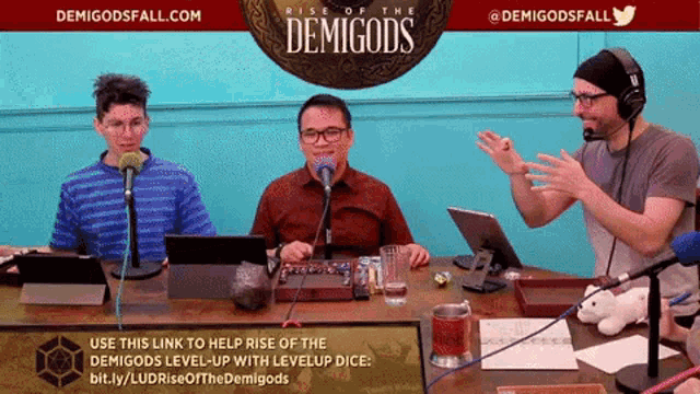 a group of people are sitting at a table with a sign that says demigods