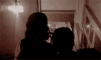 a man and woman are standing next to each other in a dark room .