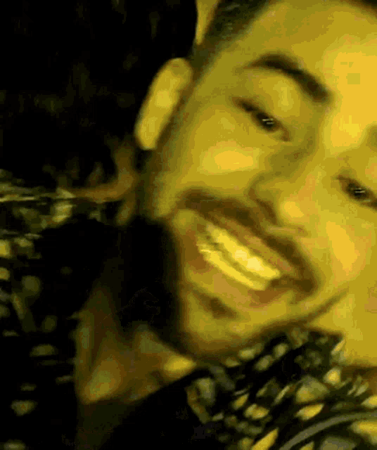 a man with a beard is smiling in a yellow background