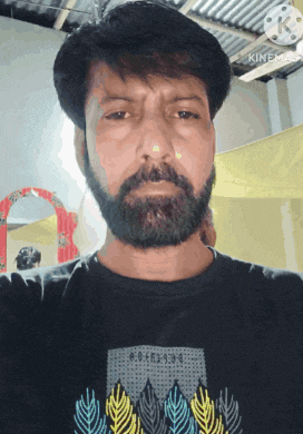 a man with a beard is wearing a black t-shirt with a leaf design