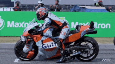 a man riding a motorcycle with a gulf logo on the side