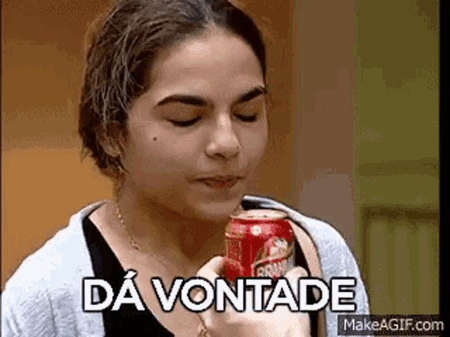 a woman is drinking a can of beer with the words da vontade written on the bottom .
