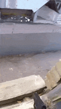 a person is holding a gun in front of a wall .