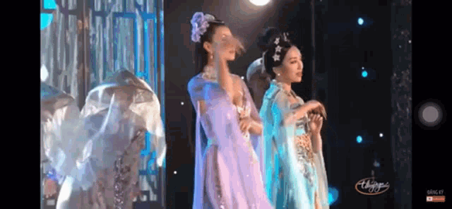 a group of women are dancing on a stage with the word thangky on the bottom left