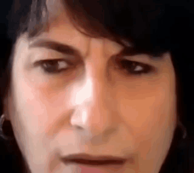 a close up of a woman 's face with a sad look on her face
