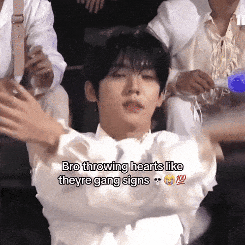 a young man is throwing hearts like theyre gang signs