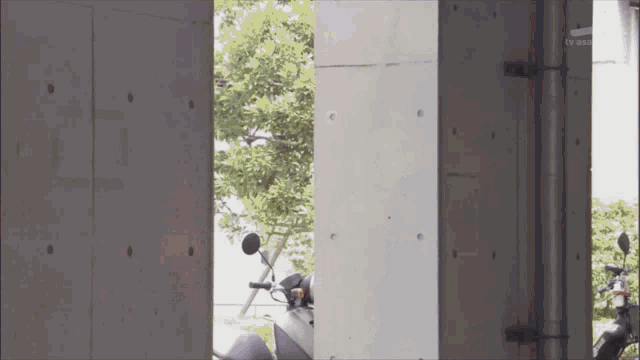 a motorcycle is parked in front of a concrete wall that says tv asahi