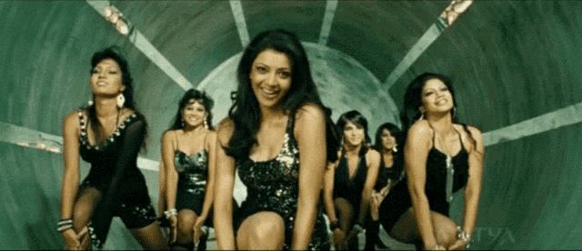 a group of women are dancing in a tunnel and one of them is smiling at the camera