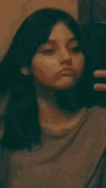 a woman is touching her hair in front of a mirror while looking at herself .