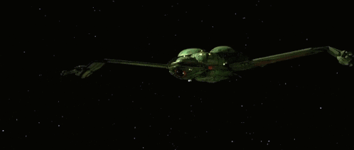a green space ship is flying through a dark space surrounded by stars .