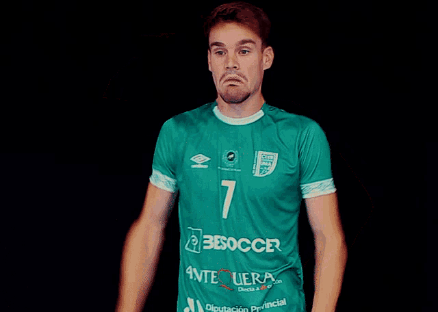 a man wearing a green jersey that says bisoccer
