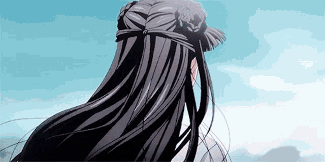 a woman with long black hair is standing in front of a blue sky with mountains in the background .