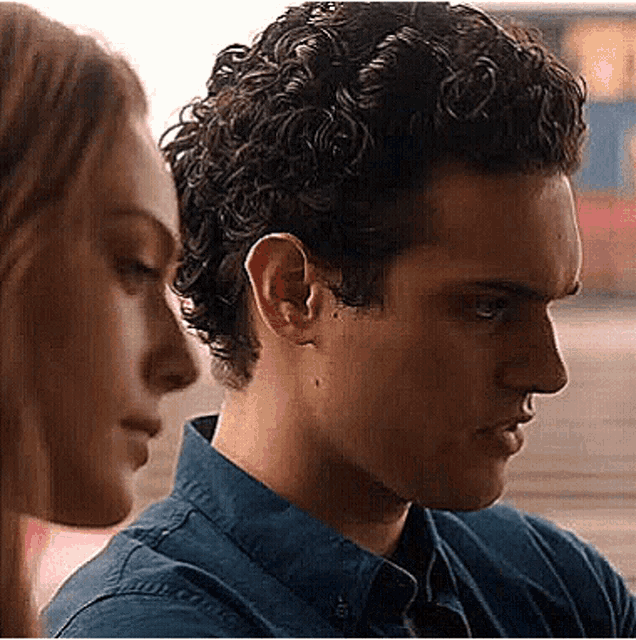 a man and a woman are looking at each other in a close up .