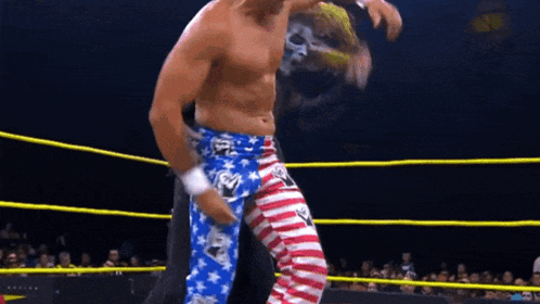 a man in a wrestling ring wearing a pair of blue and white striped pants