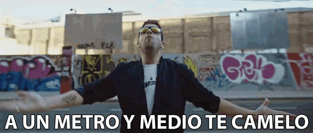 a man with his arms outstretched and the words a un metro y medio te camelo on the bottom