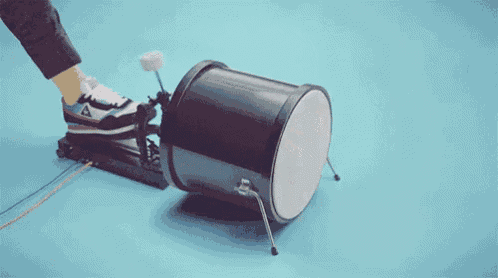 a person 's foot is pressing a drum pedal on a drum .