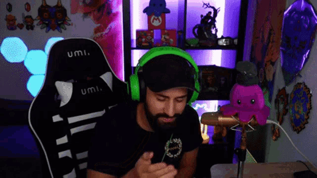 a man wearing headphones is sitting in a chair that says umi on it