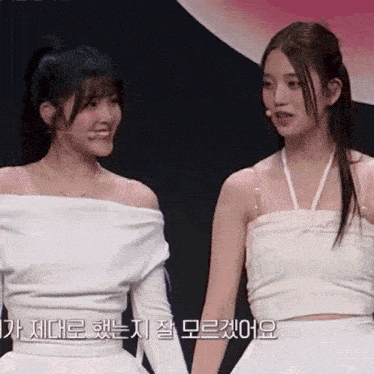 a couple of women standing next to each other with korean writing on the bottom right