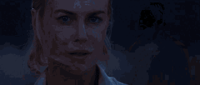 a man and a woman are looking at each other in the dark