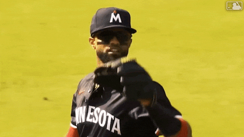 a baseball player wearing a minnesota jersey is throwing a baseball