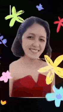 a woman in a red dress is smiling surrounded by colorful flowers