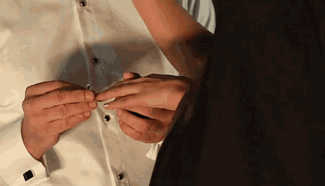 a man is putting a wedding ring on the finger of a woman