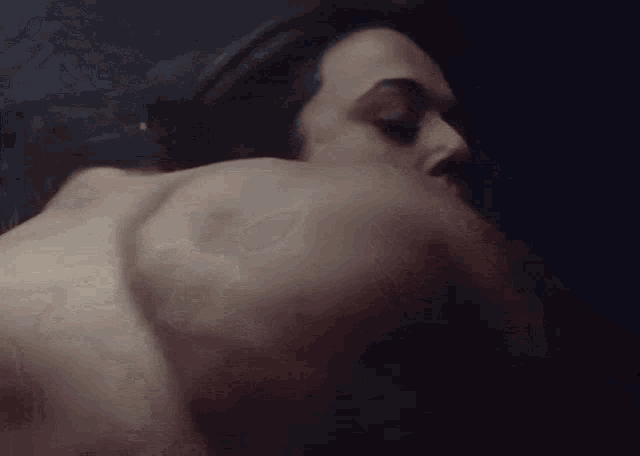 a man and woman are kissing in a dark room .
