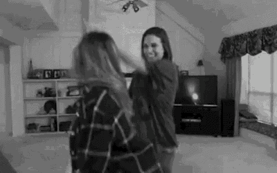 two women are dancing together in a living room .