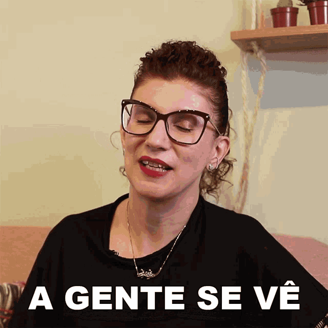 a woman wearing glasses and a black shirt says " a gente se ve " in white letters