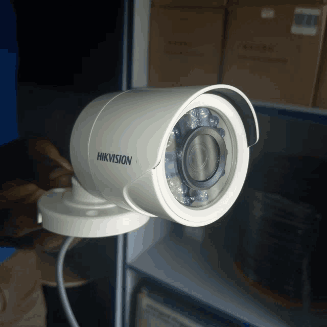 a white hikvision security camera is sitting on a table