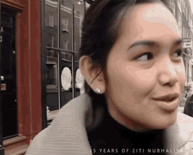 a close up of a woman 's face with the words 25 years of ziti nurhalisa written below her