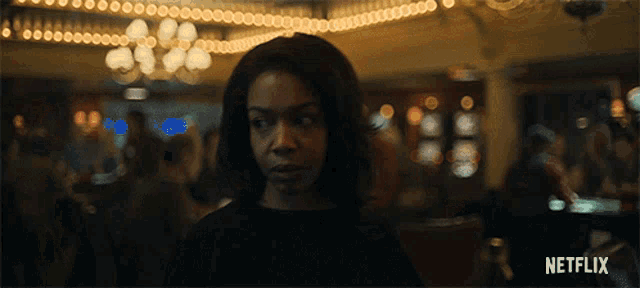 a woman in a dark room with a netflix logo