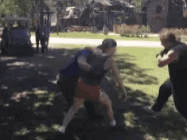 a couple of people are fighting in a park