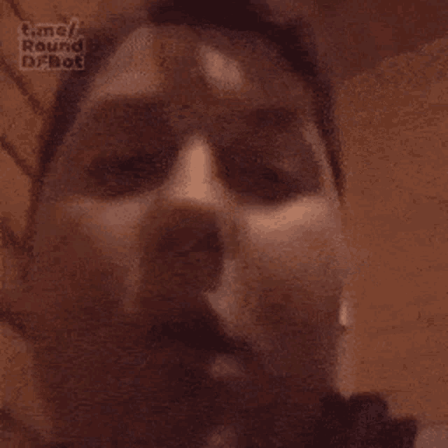 a close up of a man 's face with his mouth open and a beard .