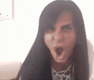 a woman is making a funny face with her mouth open .