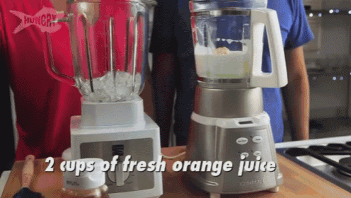two cups of fresh orange juice are being blended in a cuisinart blender