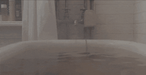 a bathtub filled with water in a bathroom with a shower curtain .