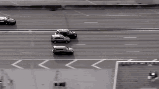 a white car is driving down a highway next to a black car