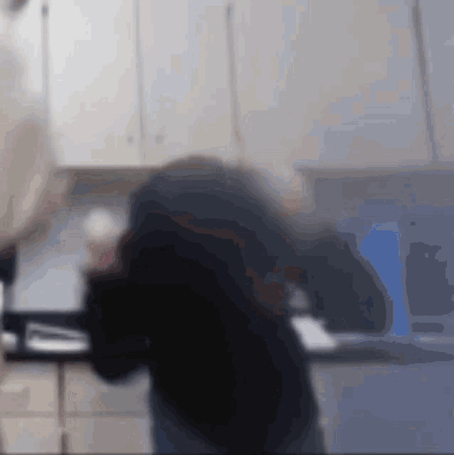 a blurry picture of a man standing in a kitchen