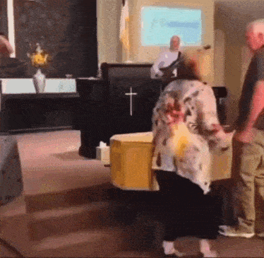 a woman standing in front of a podium with a cross on it