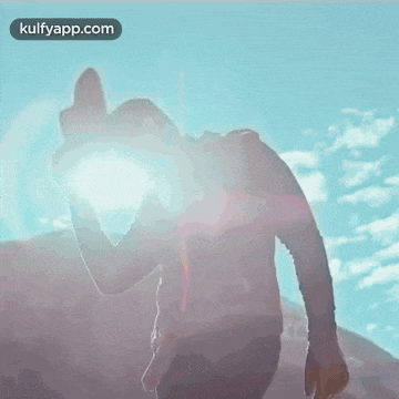 a man with a backpack is taking a picture of the sun with his camera .