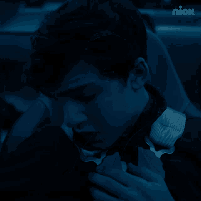 a man is sitting in a car with his mouth open and a nick logo in the corner