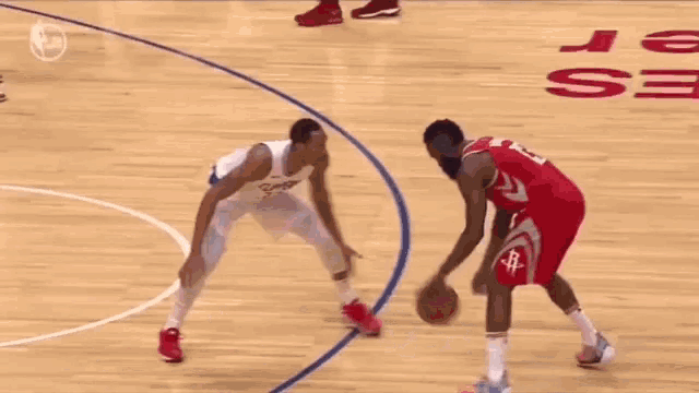 a basketball game is being played on a court with a referee in the middle .
