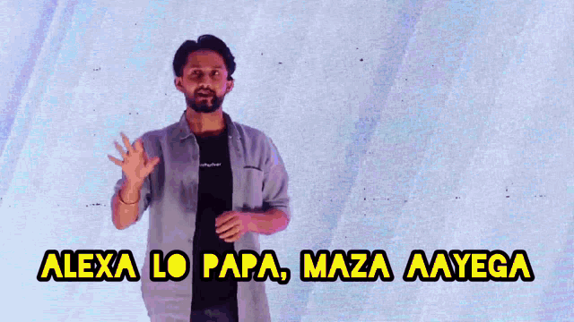 a man stands in front of a wall with the words alexa lo papa maza aayega