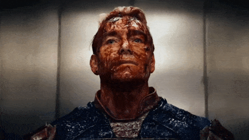 a man with blood on his face is looking up at the camera