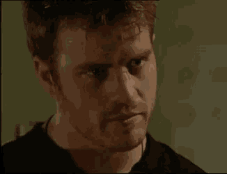 a close up of a man 's face with a black shirt on .